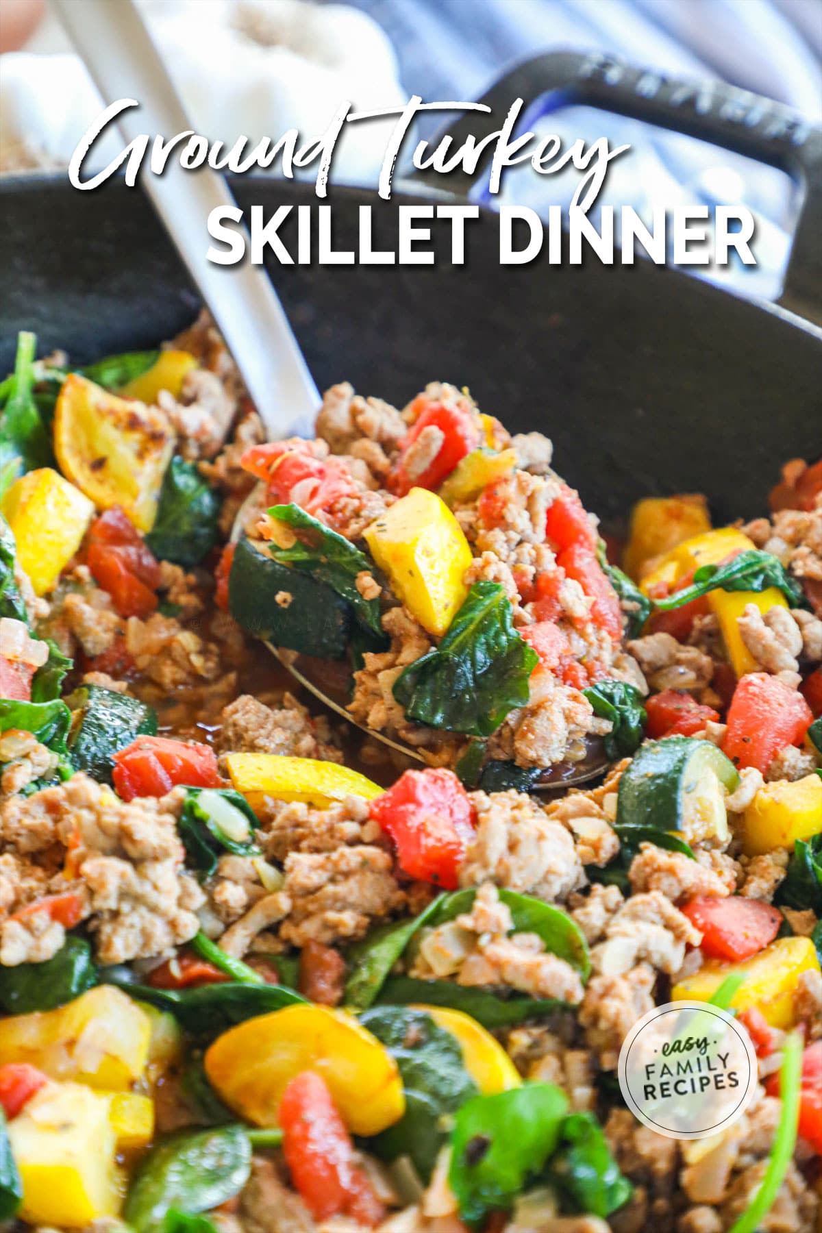 An Italian ground turkey skillet with tomatoes, spinach, green, and yellow squash.