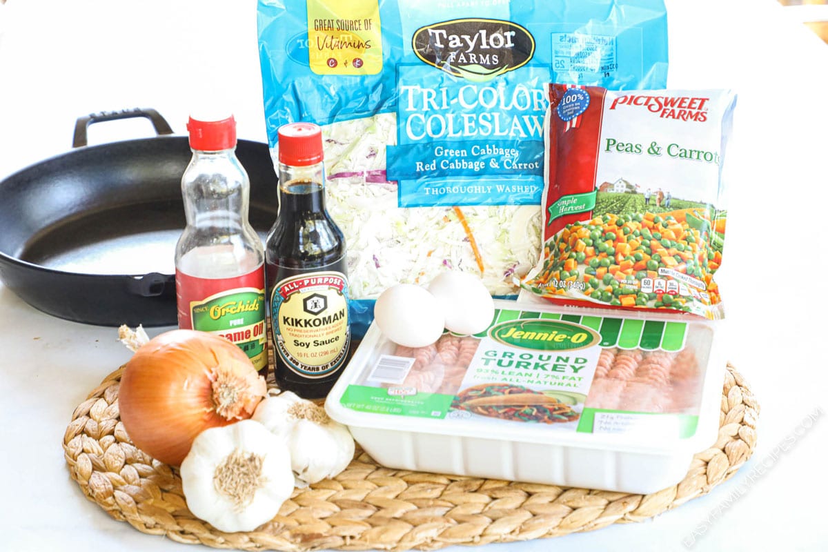 Ingredients to make ground turkey stir fry including mixed vegetables, cabbage, eggs, and onion