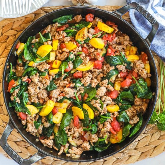 A pan of Italian seasoned ground turkey with spinach, squash, and tomatoes.