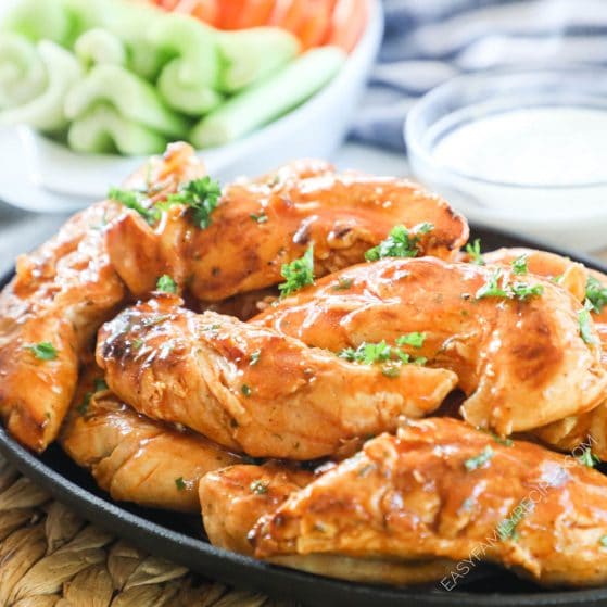 A platter of saucy, buffalo style chicken tenders without breading