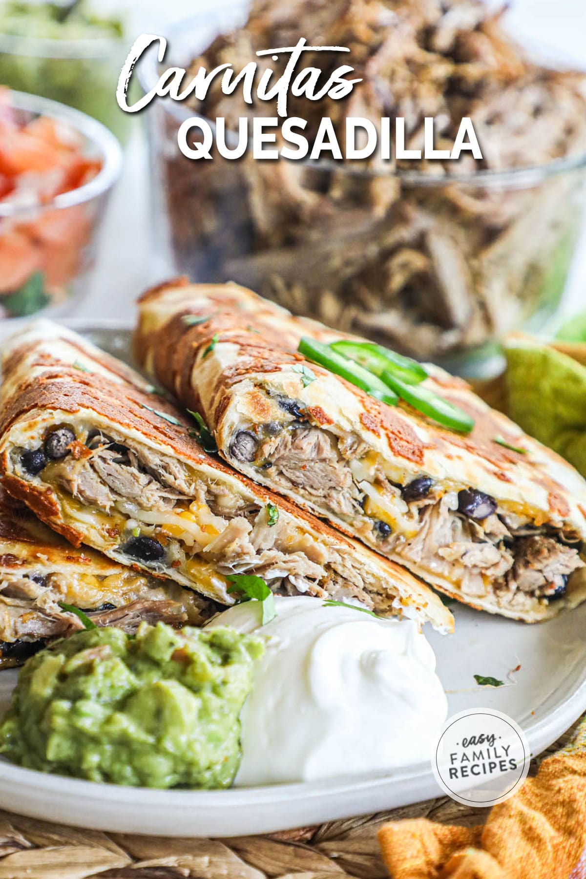 serving of carnitas quesadillas cut into 3 pieces and served with guacamole and sour cream