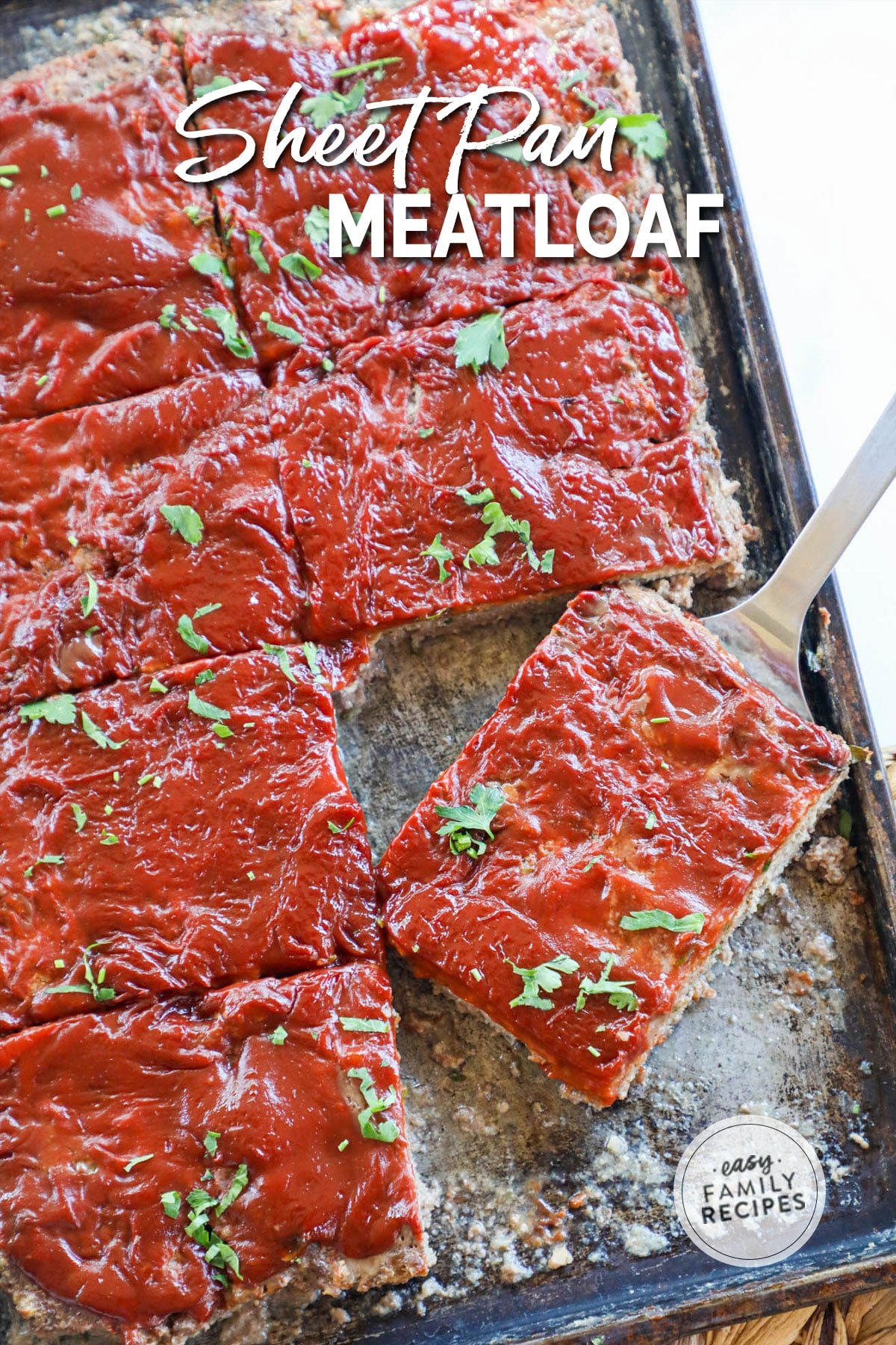 Lifting a slice of fast cooking meatloaf from sheet pan to serve for an easy dinner.