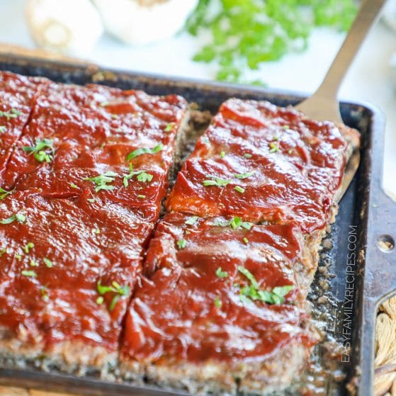 Southern meatloaf prepared on a sheet pan covered in a thick delicious meatloaf sauce