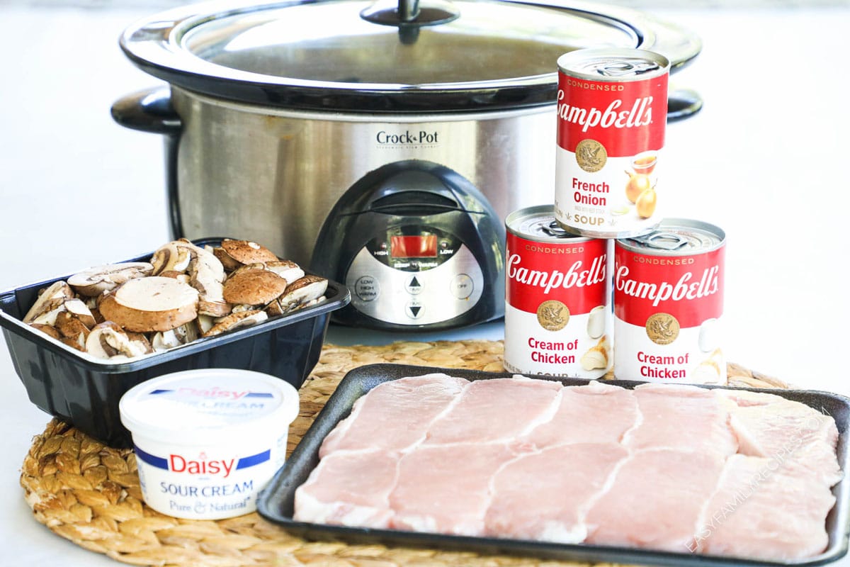 Ingredients to make creamy smothered pork chops including boneless pork chops, condensed soup, sour cream, and mushrooms.