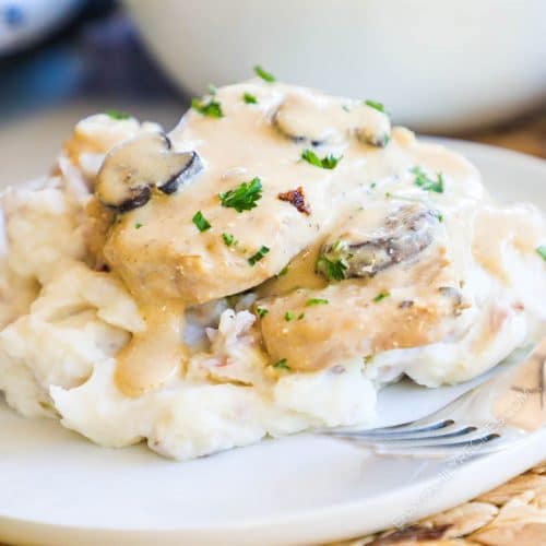 Crock Pot smothered pork chops on a pile of mashed potatoes