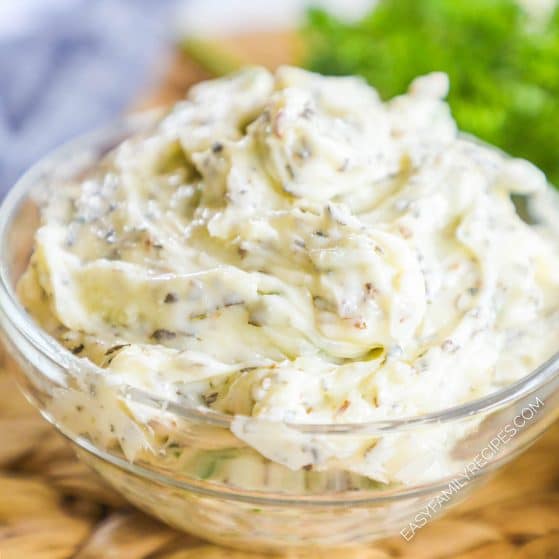 Small glass bowl with creamy garlic herb butter.