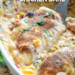 Lifting chicken breast with queso out of the baking dish.