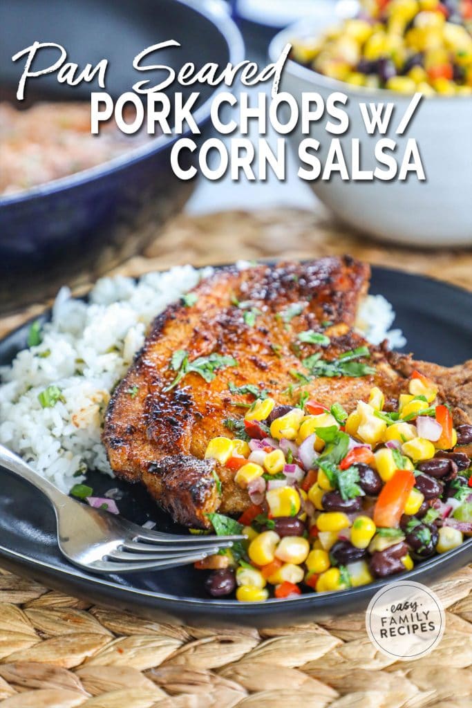 A serving plate with a bone in pork chop over rice and served with corn salsa with black beans