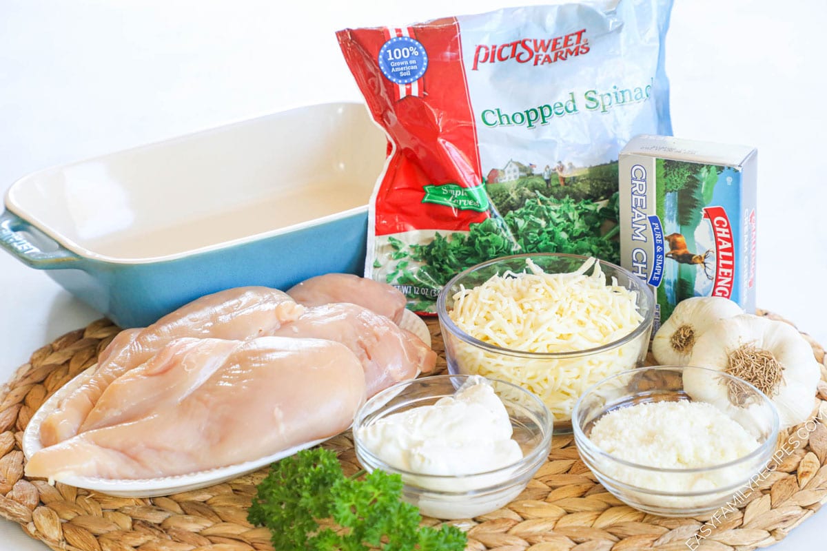 Ingredients for making a creamy spinach chicken bake including parmesan, sour cream, frozen spinach, and mozzarella
