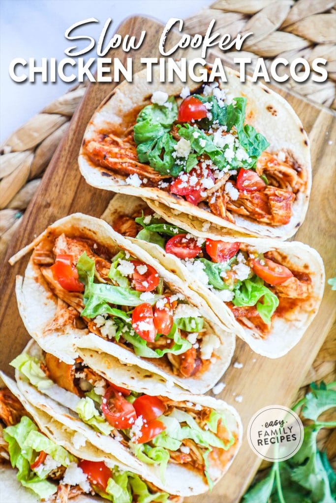 5 tacos filled with recipe and toppings on a cutting board.