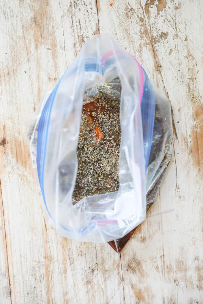 First step image showing the ingredients of the marinade in a plastic bag.