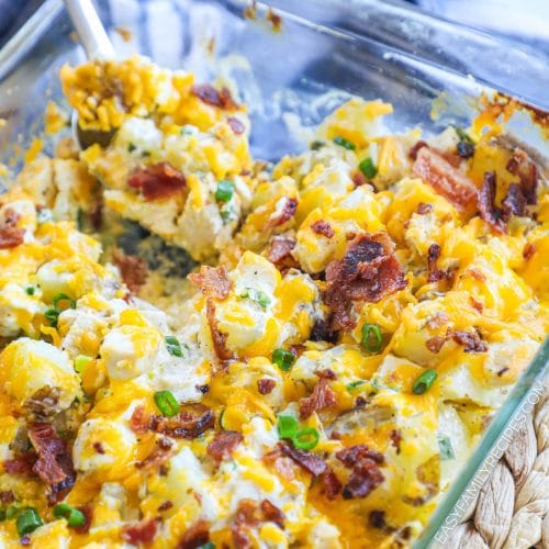 Close up of loaded baked potato chicken casserole being scooped out of a pan.