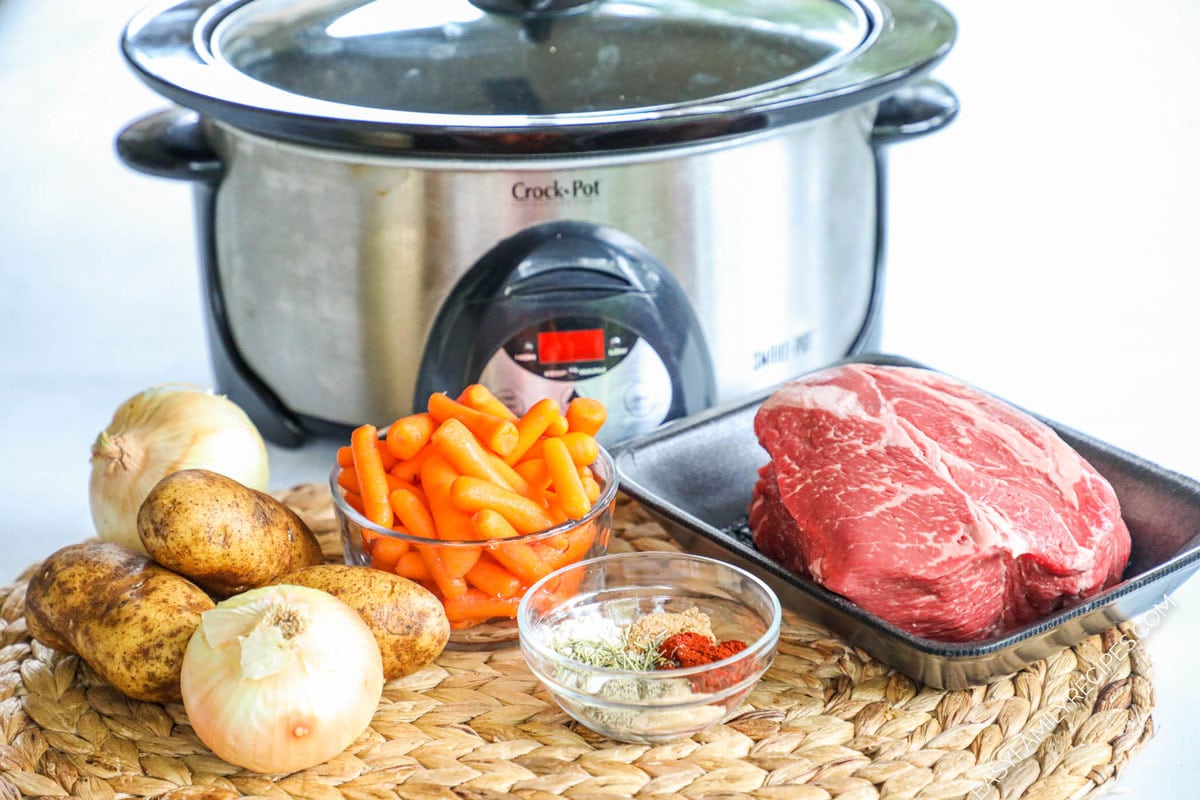 Ingredients to make Crock Pot Southern Pot Roast including chuck roast, carrots, potatoes, onions, and seasonings