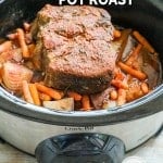 slow cooker cooking with pot roast on top of potatoes and carrots