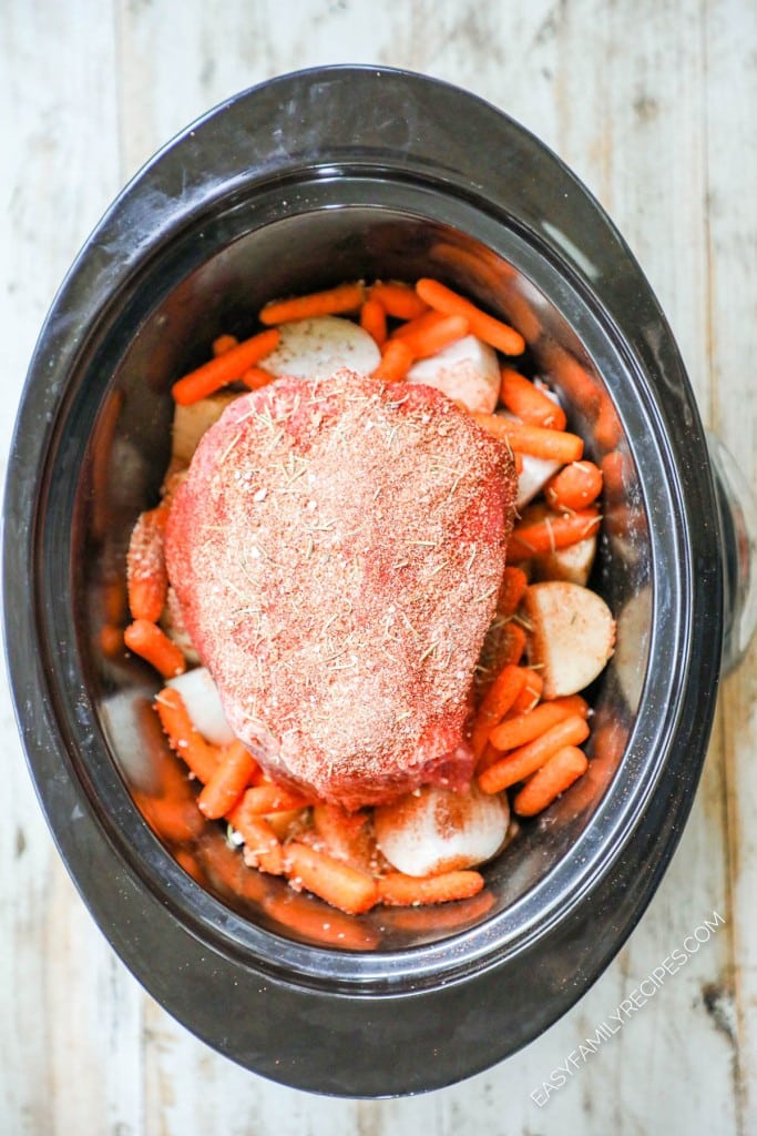 Pot roast with carrots and potatoes in slow cooker ready to cook