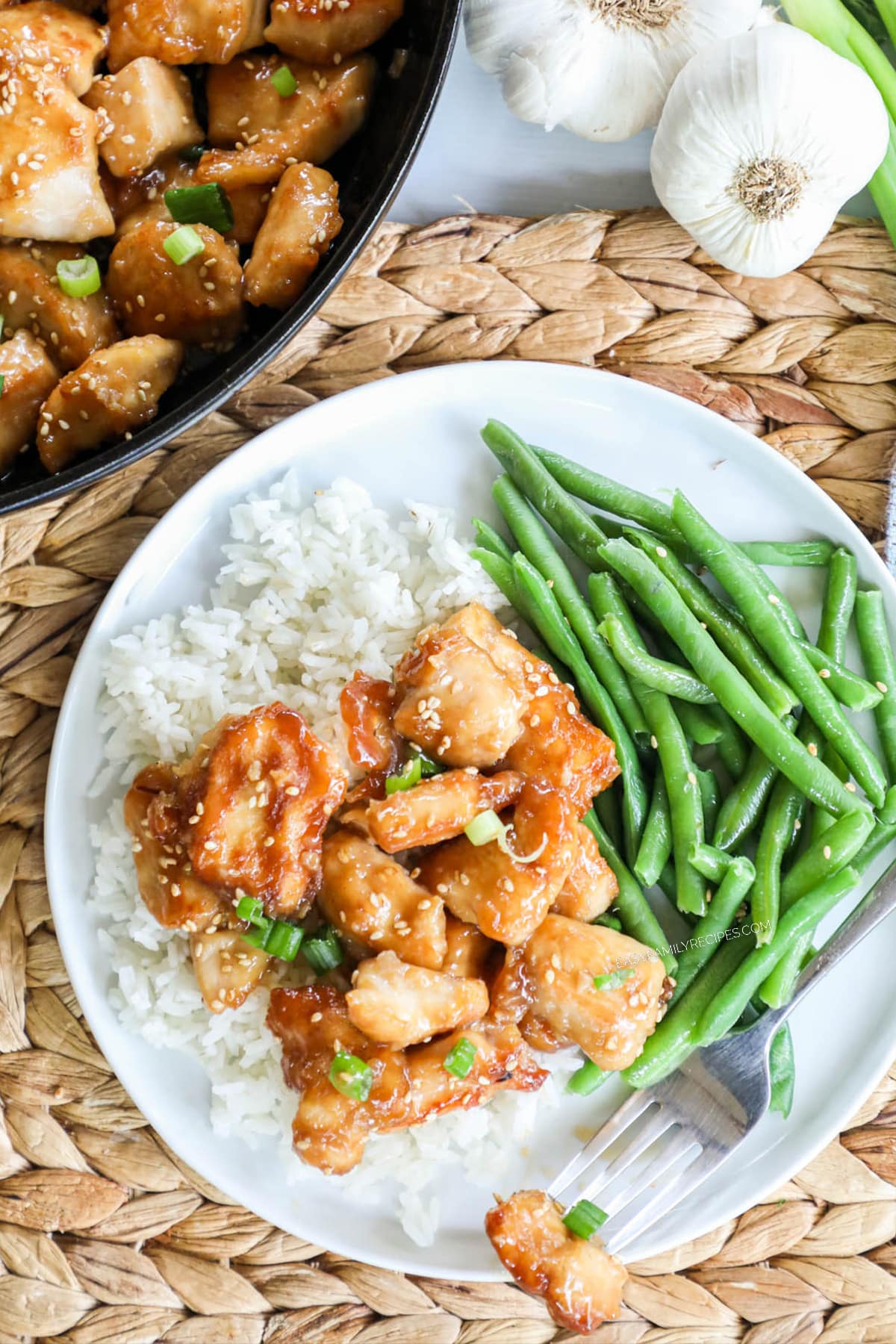 Honey sesame chicken served with rice and green beans.