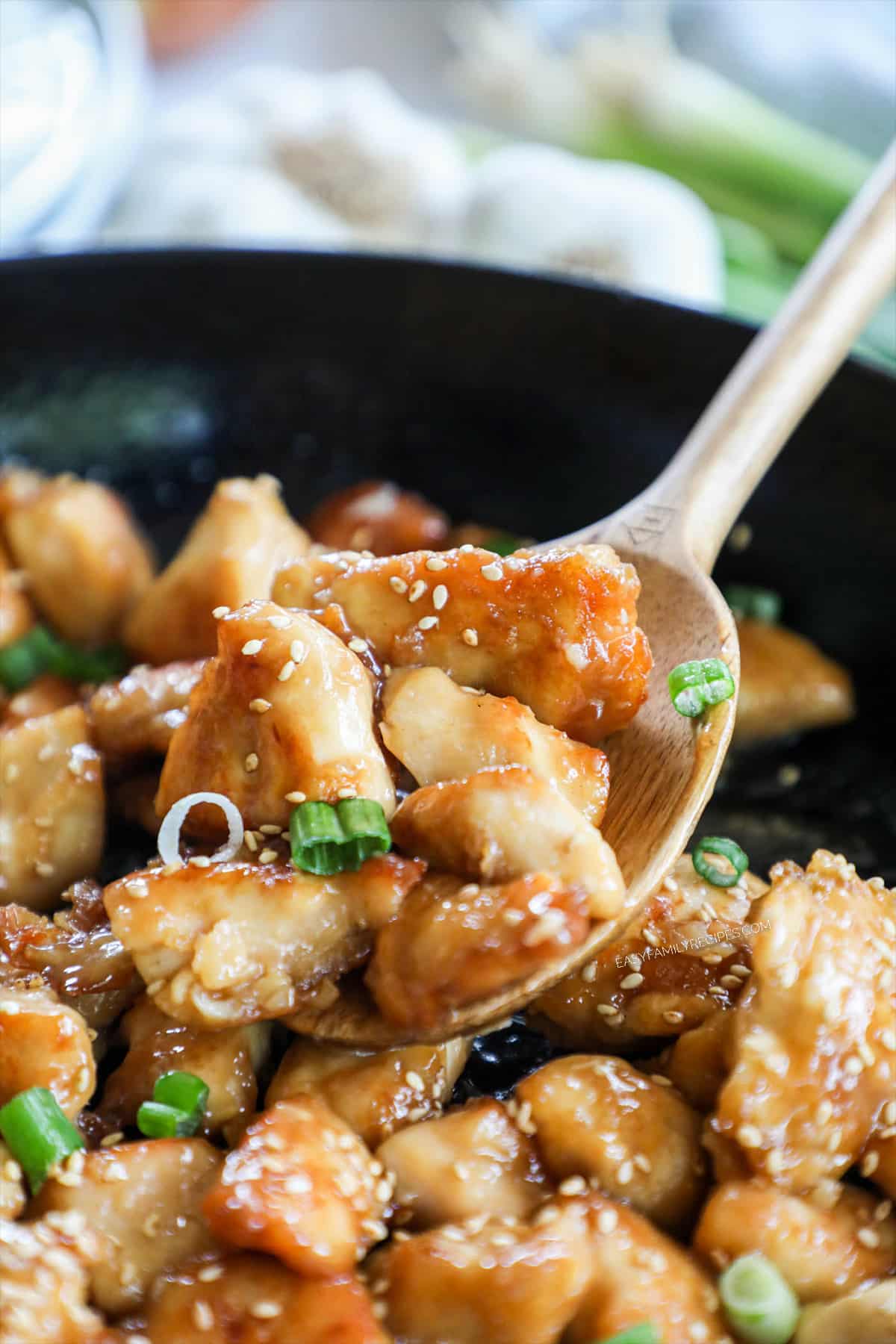 Close up of scooping Honey Sesame Chicken Bites out of the skillet.