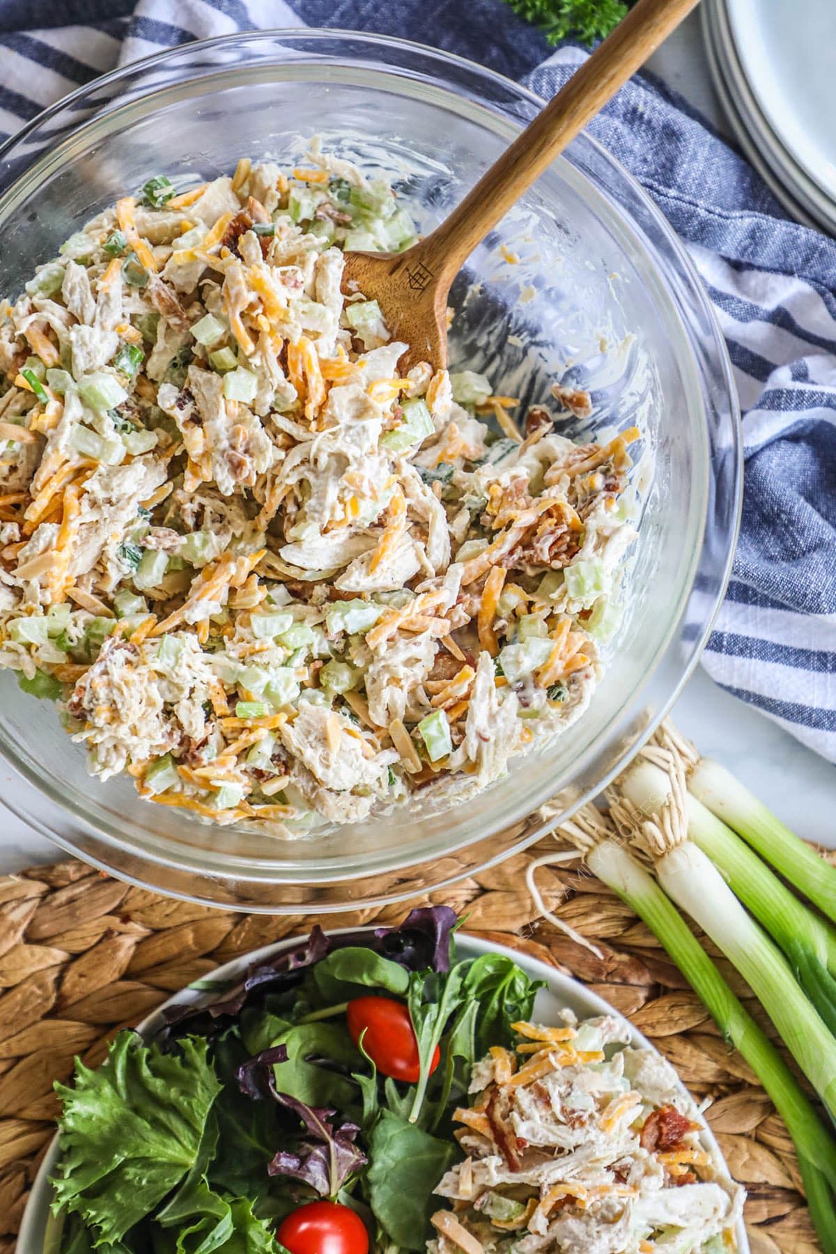 A bowl of the chicken salad mixed well with bites and green, orange, and purple.