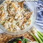 A bowl of the chicken salad mixed well with bites and green, orange, and purple.