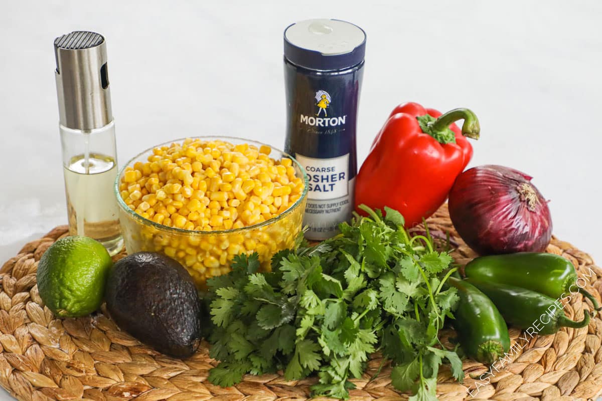 Ingredients for recipe before being prepped: oil, lime, avocado, corn, salt, cilantro, red pepper, red onion, and jalepenos.