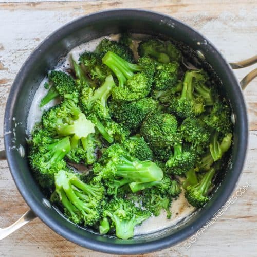 Top down view into a saucepan with broccoli in foamy brown butter.