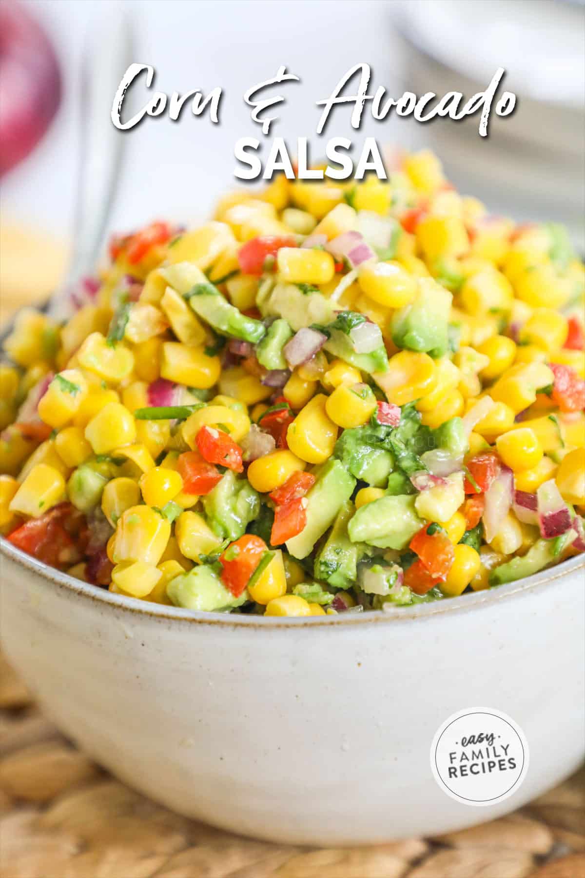 Corn and Avocado salsa in a deep bowl piled high above the rim of bowl.