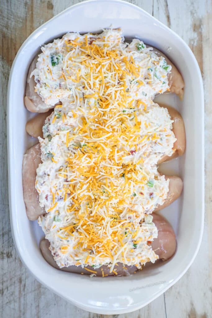 How to make Million Dollar Chicken Step 3: Lay chicken breast in a baking dish. Season with salt and pepper then spread the creamy bacon mixture over the top.