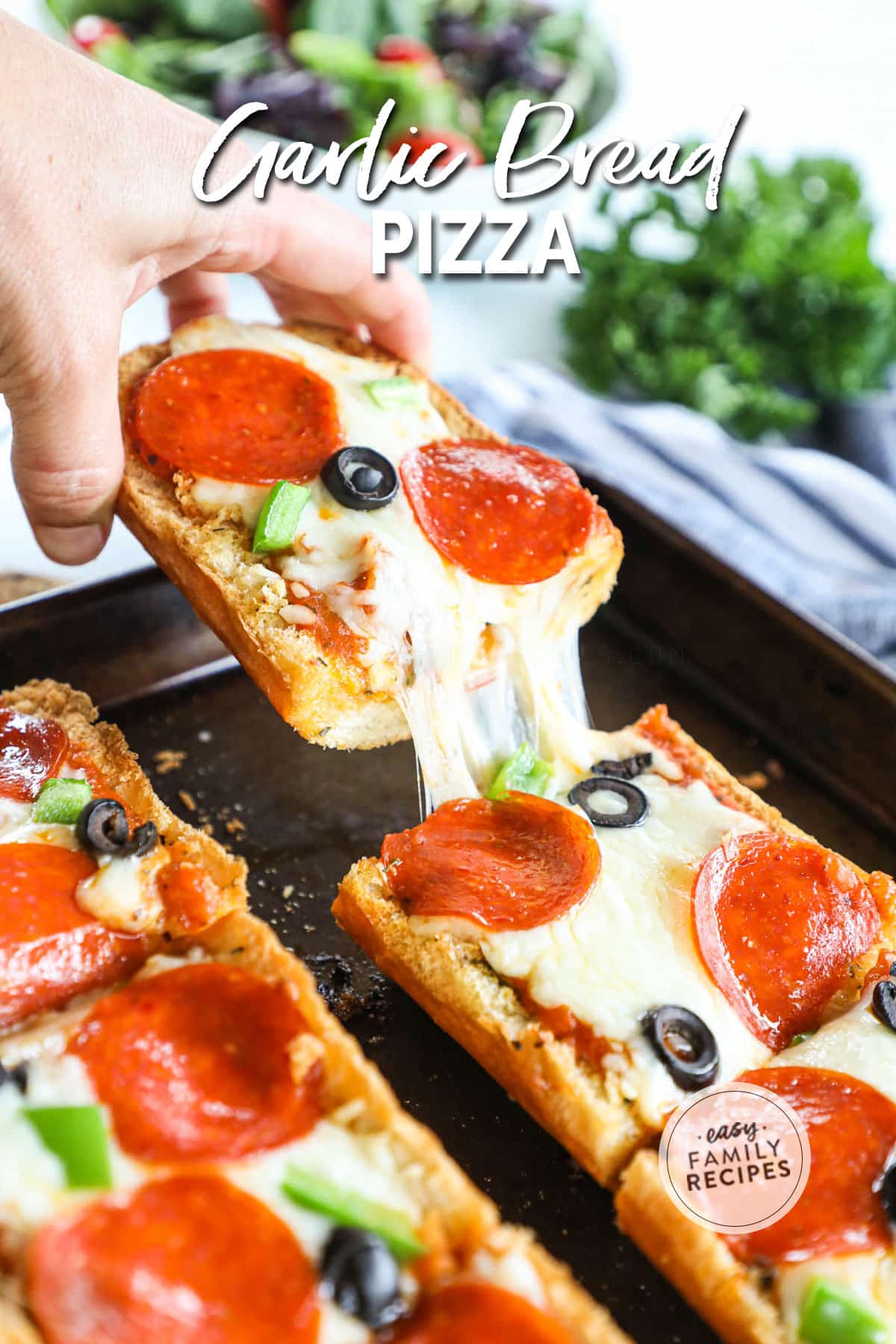 Garlic bread pizza with supreme toppings being pulled with gooey cheese.