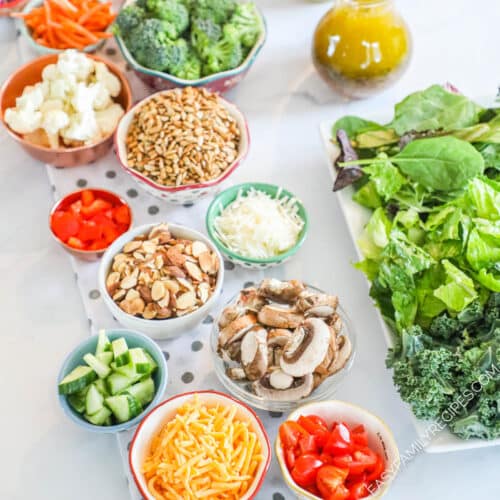 Overhead view of salad bar ingredient options such as romaine lettuce, tomatoes, cucumber, cheese, and buttermilk ranch dressing