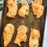 Homemade breaded shake and bake chicken on a baking sheet garnished with parsley