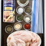 Ingredients for making homemade shake and bake chicken on a baking sheet
