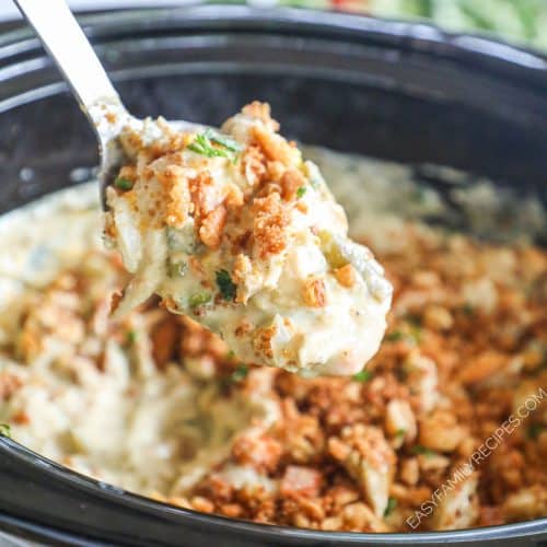 a spoon scooping creamy crustless chicken pot pie with ritz cracker crumbs from a Crock Pot.