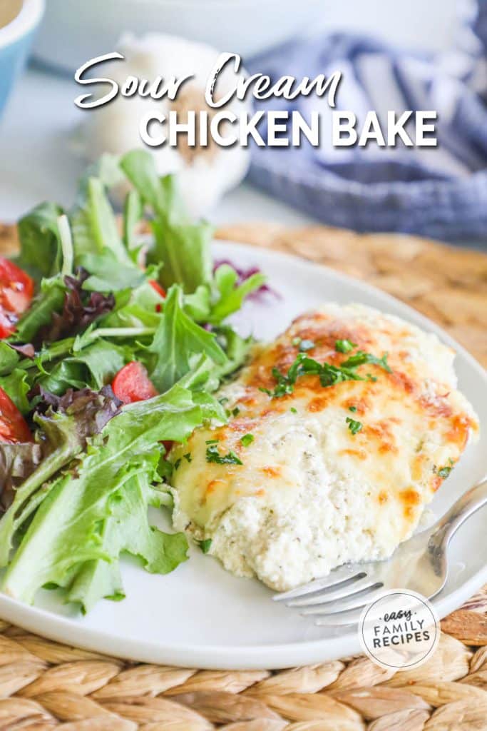 A plate with smothered sour cream chicken on a plate next to a salad.