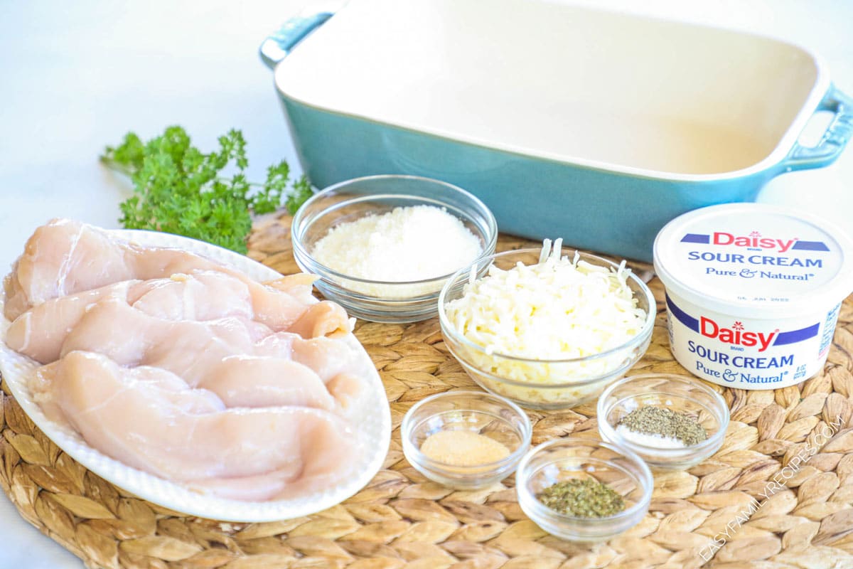 Ingredients for sour cream chicken including chicken breast, parmesan, mozzarella, sour cream, salt, pepper, oregano, and garlic powder.