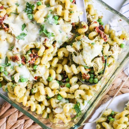 cheesy baked pesto chicken pasta in a casserole dish.