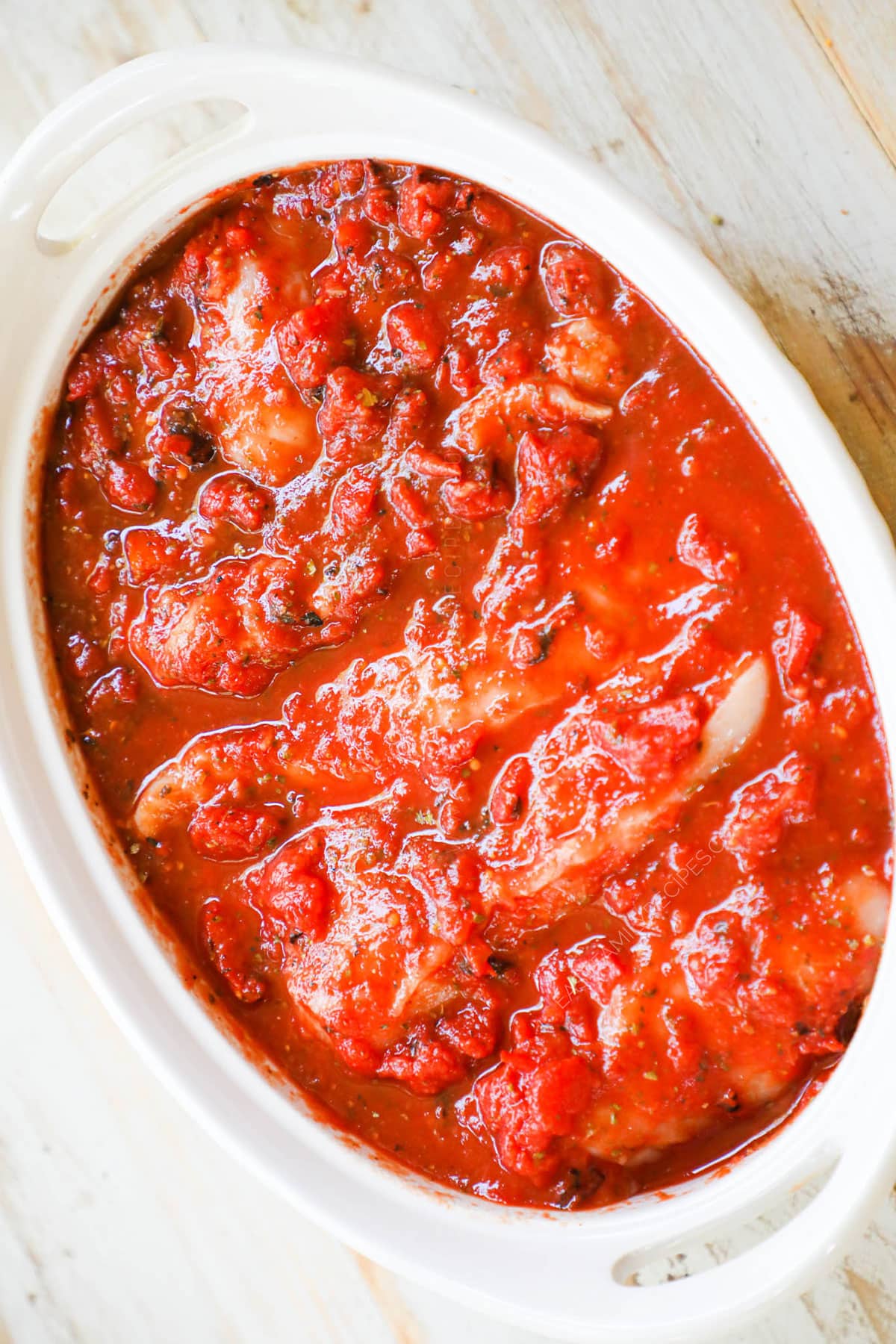 Steps to make chicken and peppers step 3 - Mix the crushed tomatoes, remaining seasonings, garlic, and vinegar together and pour over the top of the chicken to cover.
