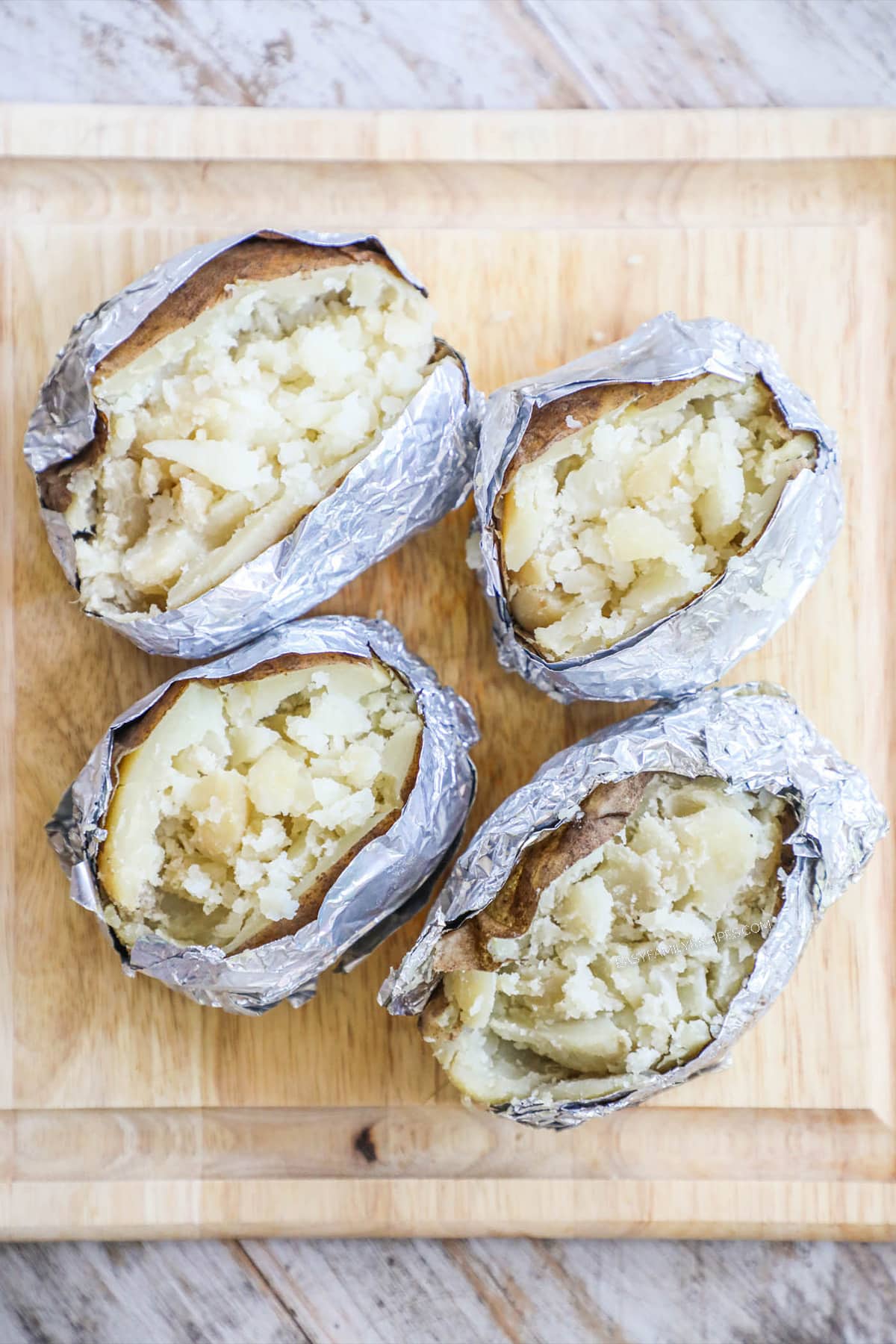 Step 1 of Chili Stuffed Baked Potatoes - Split baked potatoes and fluff with a fork.