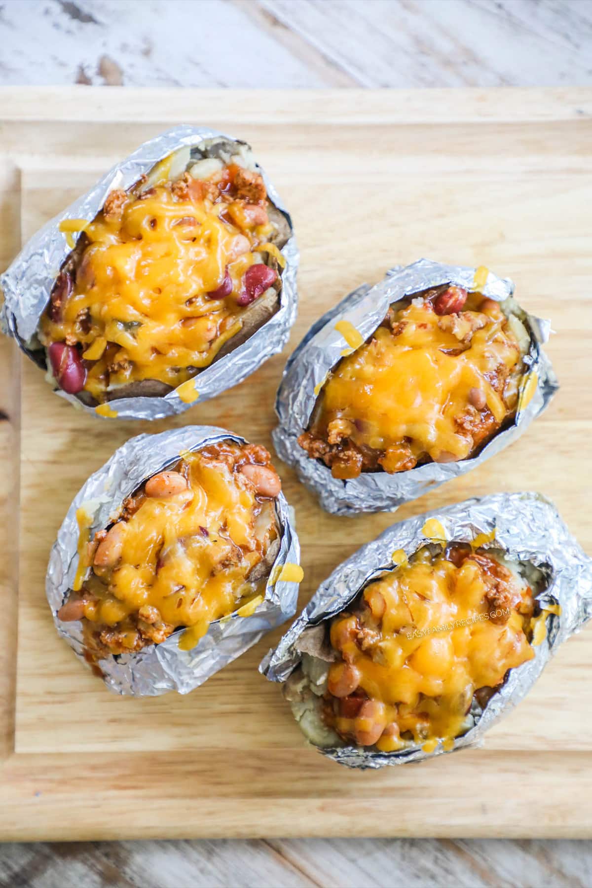 Step 4 image of stuffed baked potato that has chili, bacon, and melted cheese after baking in the oven.