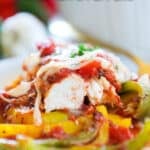 Close up shot of baked italian chicken and peppers - it is cut so you can see the inside