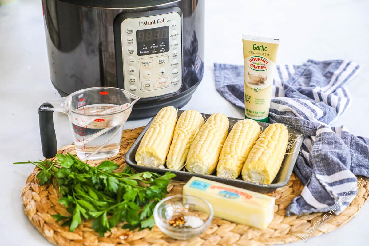 Ingredients for corn on the cob including corn, water, butter, garlic paste, and herbs.