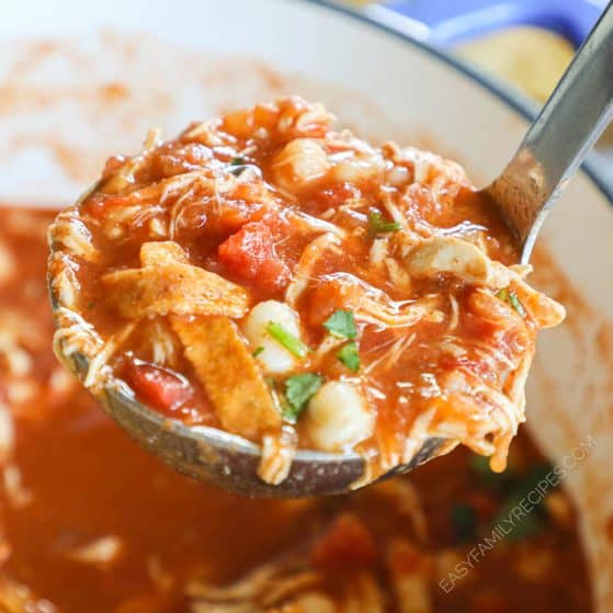 a ladle full of chicken tortilla soup being lifted from a pot.