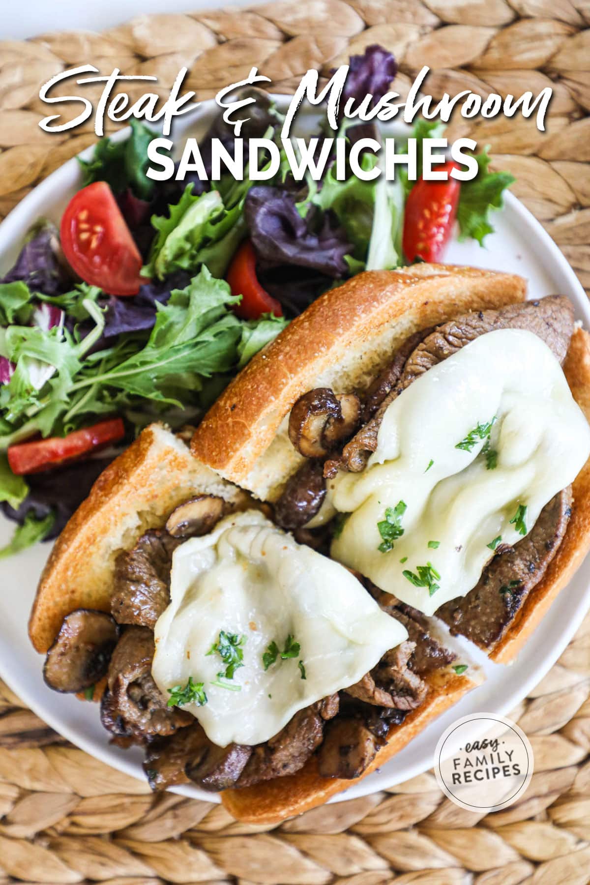 Steak and mushroom sandwich with melted cheese on toasted bread next to a side salad.
