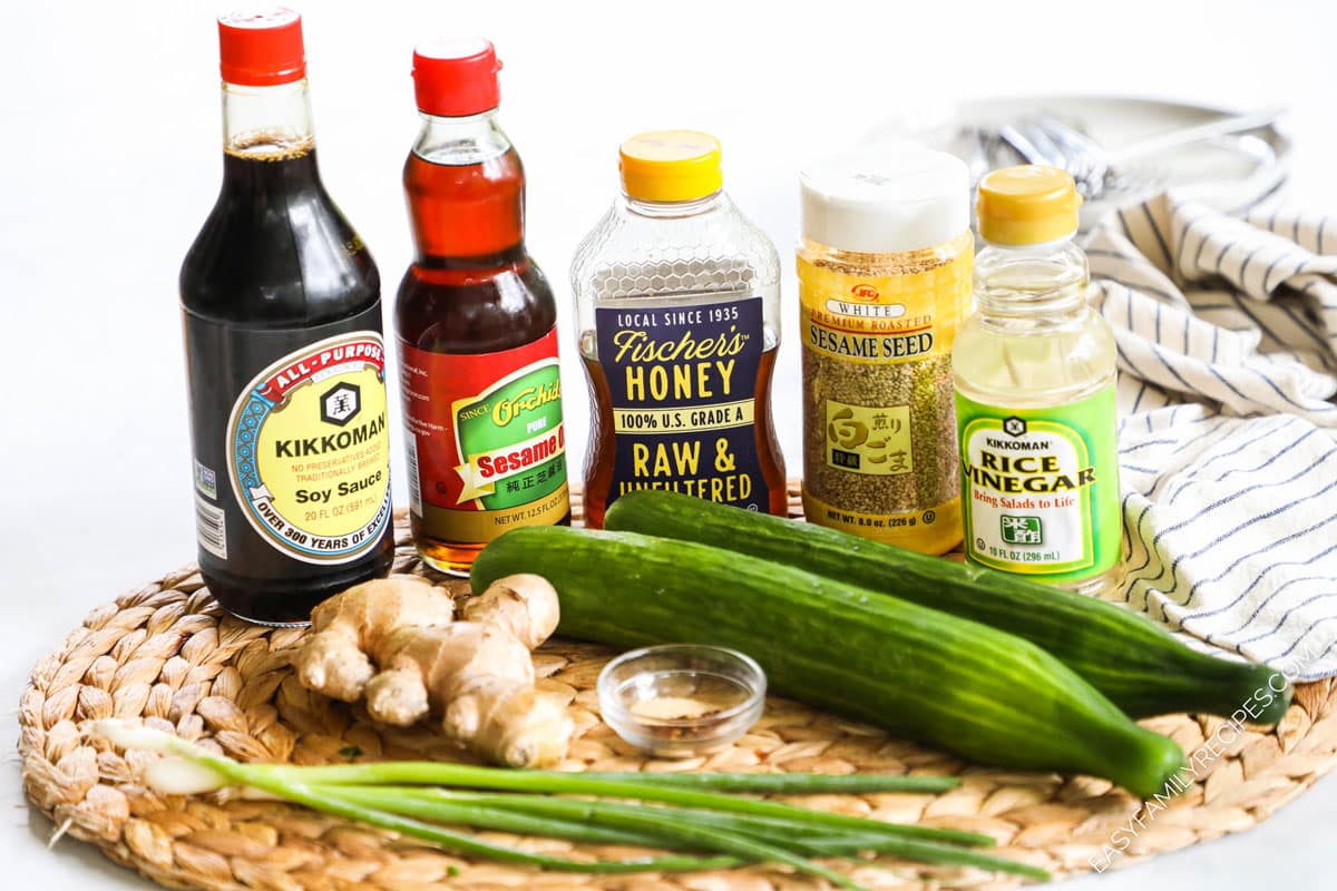 Ingredients for asian cucumber salad including soy sauce, sesame oil, cucumbers, salt, green onions, rice vinegar, chili flakes, and ginger.