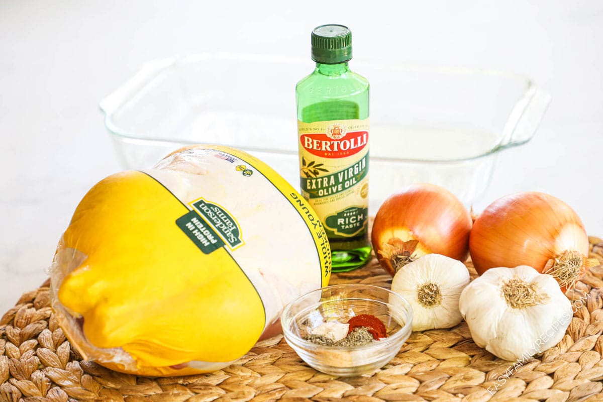 Ingredients for making baked rotisserie chicken in the oven including onions, seasonings, and oil.