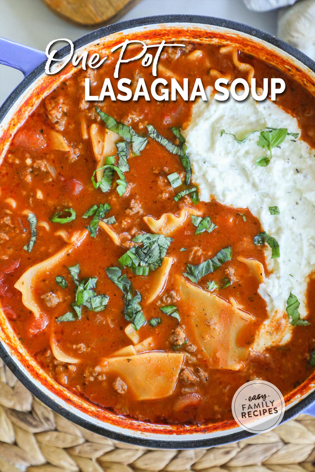 a soup pot with lasagna soup topped with creamy ricotta.