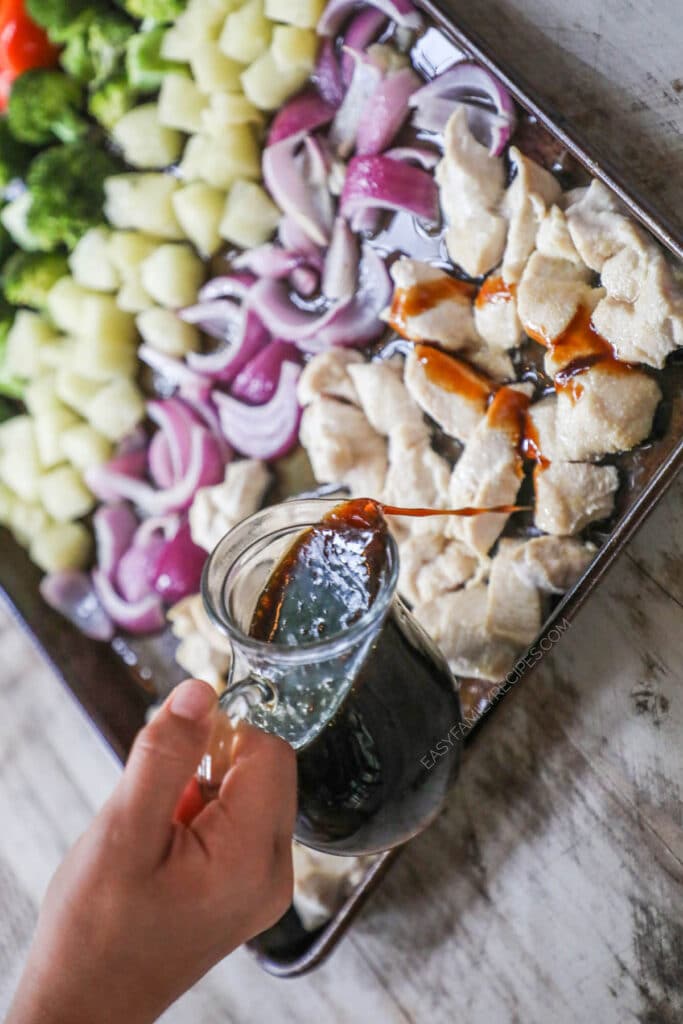How to make Sheet Pan Pineapple Chicken step 2: Mix up the sauce and pour over chicken and vegetables. Toss until coated.