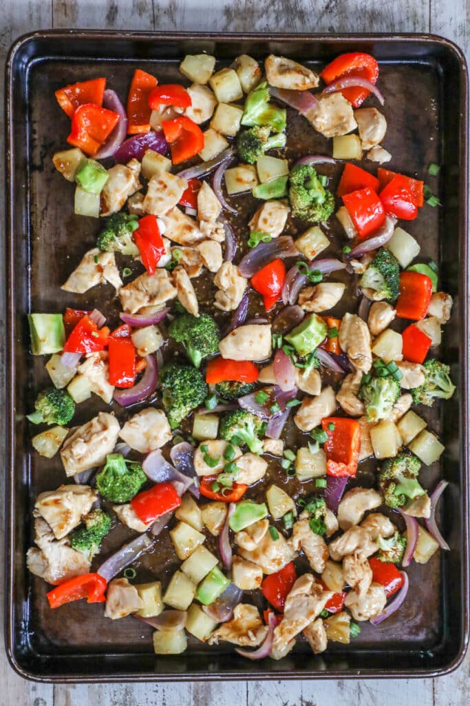 How to make Sheet Pan Pineapple Chicken step 4: Toss all of the chicken and veggies together and add more sauce.