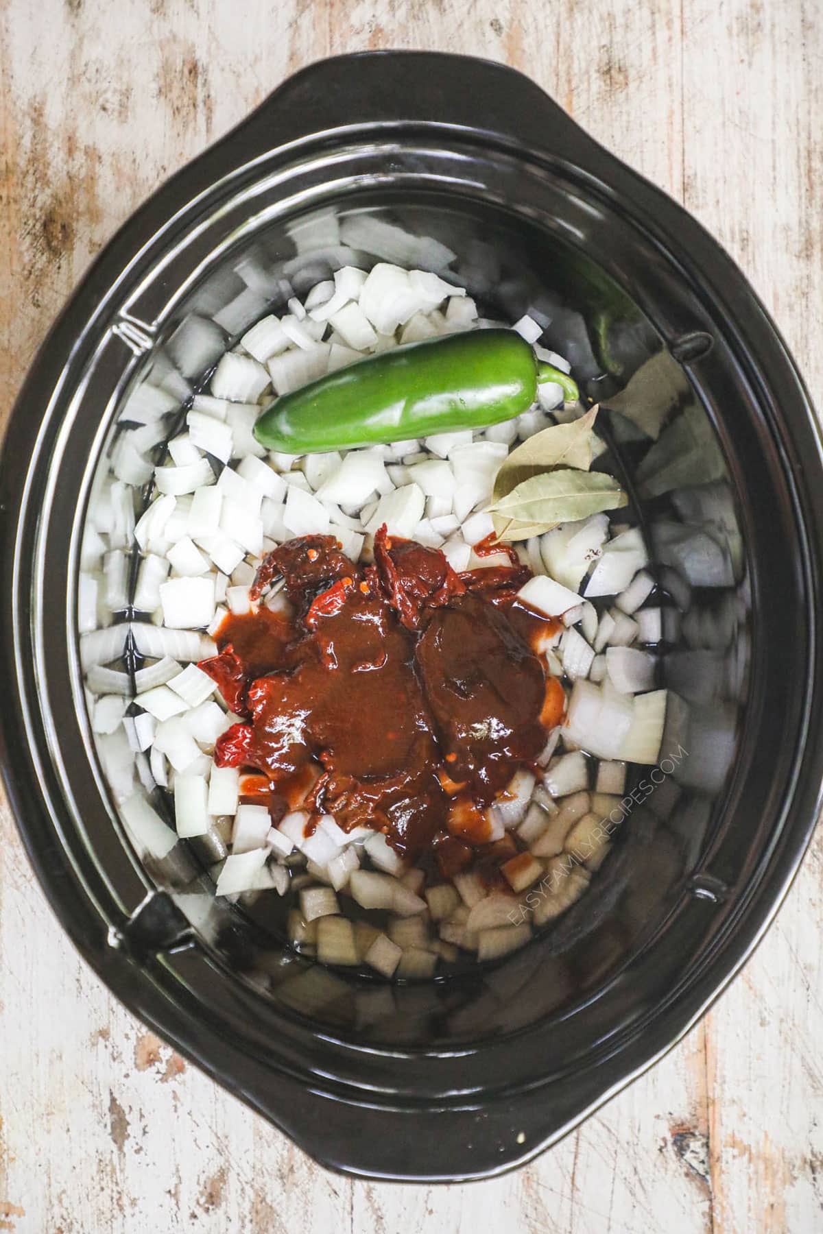 How to make Beef Barbacoa Step 1 - Add onion, chipotle peppers and sauce from the can (remove the seeds and ribs from the peppers for a milder flavor,) jalapeno pepper, apple juice, lime juice, and bay leaf to the slow cooker