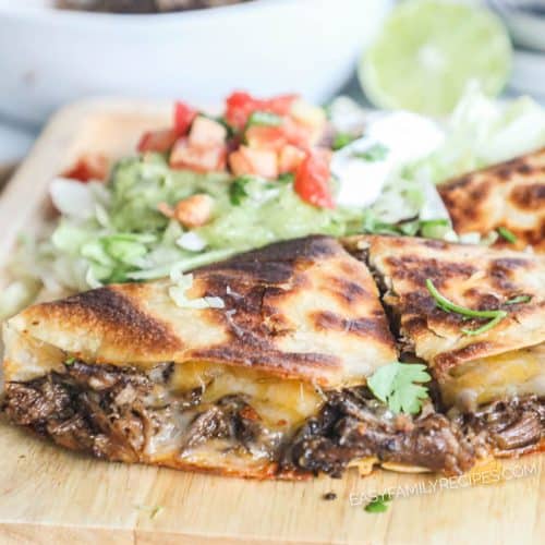 Barbacoa quesadilla that is golden brown and topped with guacamole and pico.