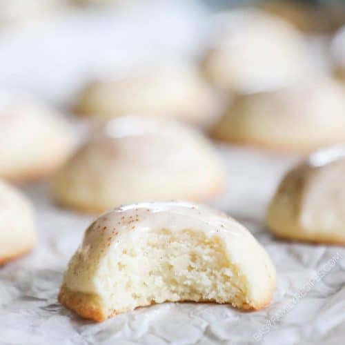 A tray of butter cookies with one having a bite taken out of it.